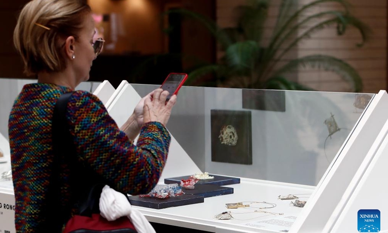 A visitor takes photos during the fair of Romanian Jewelry Week at the National Library in Bucharest, Romania, Oct. 5, 2024. (Photo by Cristian Cristel/Xinhua)