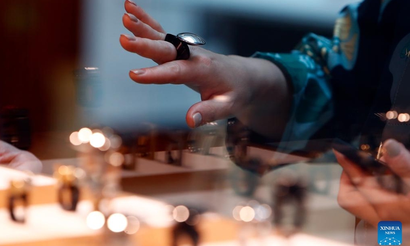 A visitor tries on a concept creation during the fair of Romanian Jewelry Week at the National Library in Bucharest, Romania, Oct. 5, 2024. (Photo by Cristian Cristel/Xinhua)