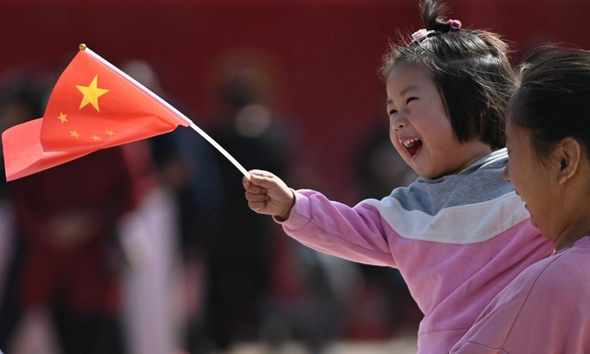 A child holding a Chinese national flag enjoys herself at a wetland park in Xigang Town, Tengzhou City of east China's Shandong Province, Oct. 1, 2024. The 75th anniversary of the founding of the People's Republic of China was observed on Tuesday in various ways across the country . (Photo by Li Zhijun/Xinhua)