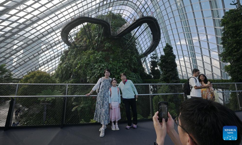 Tourists pose for photos inside the Cloud Forest at Singapore's Gardens by the Bay on Oct. 3, 2024. (Photo by Then Chih Wey/Xinhua)