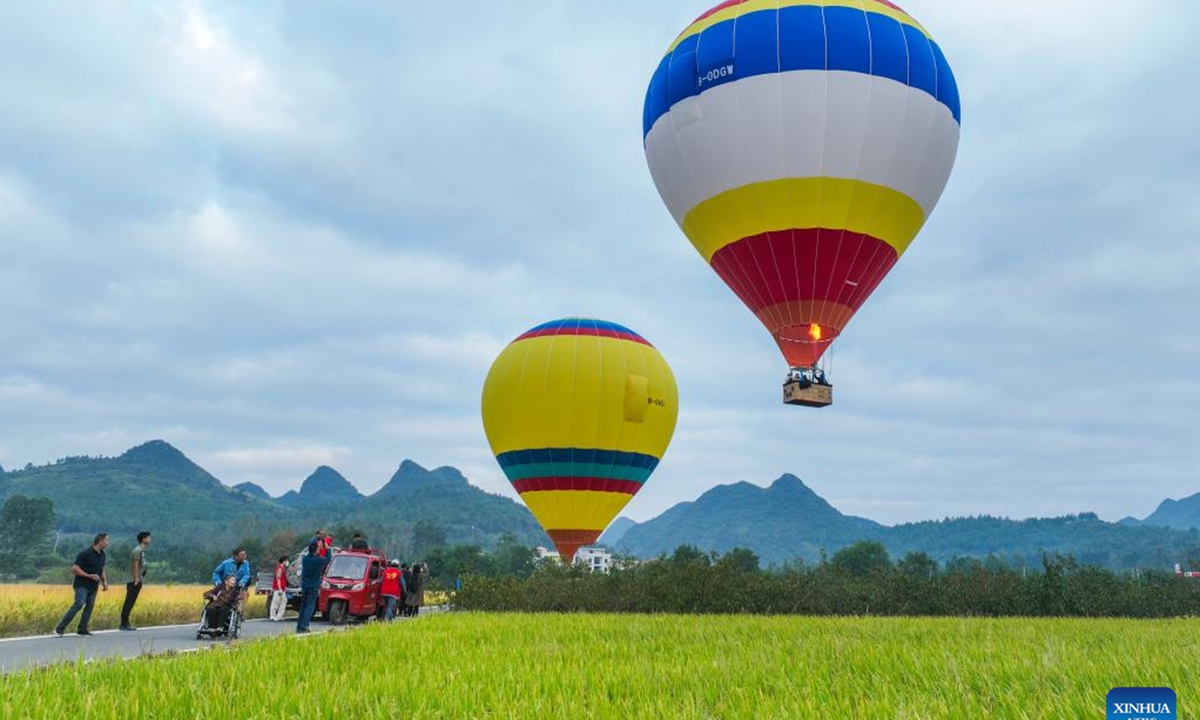 A drone photo taken on Oct. 6, 2024 shows tourists taking hot air balloons for sightseeing in Wanjing Town of Ningyuan County, central China's Hunan Province. During the week-long National Day holiday starting on Oct. 1, Chinese people take a break to travel and enjoy leisure activities. People's increasing strong demand for diversified vacation options has given rise to more abundant and diverse cultural and tourism products in the tourism market during the holiday. (Photo: Xinhua)