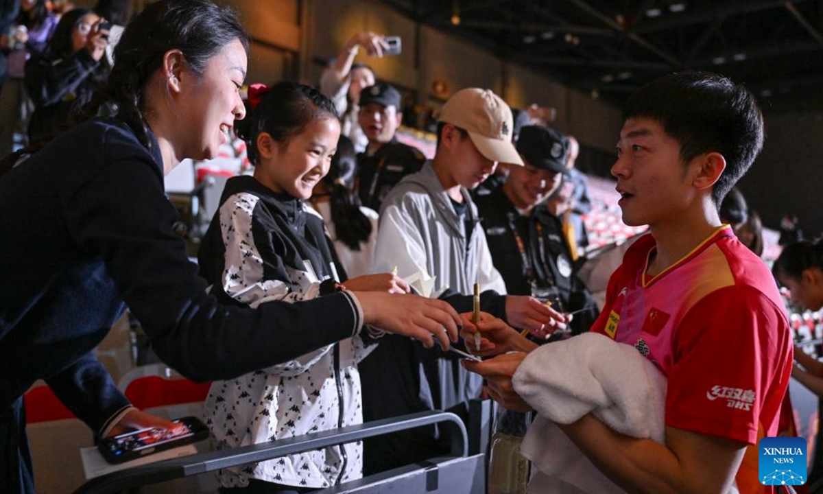 Yuan Licen (1st R) of China signs for fans after the mixed doubles 2nd round match between Yuan Licen/Shi Xunyao of China and Robert Gardos/Sofia Polcanova of Austria at 2024 World Table Tennis (WTT) China Smash in Beijing, China, Oct. 1, 2024.  (Photo: Xinhua)