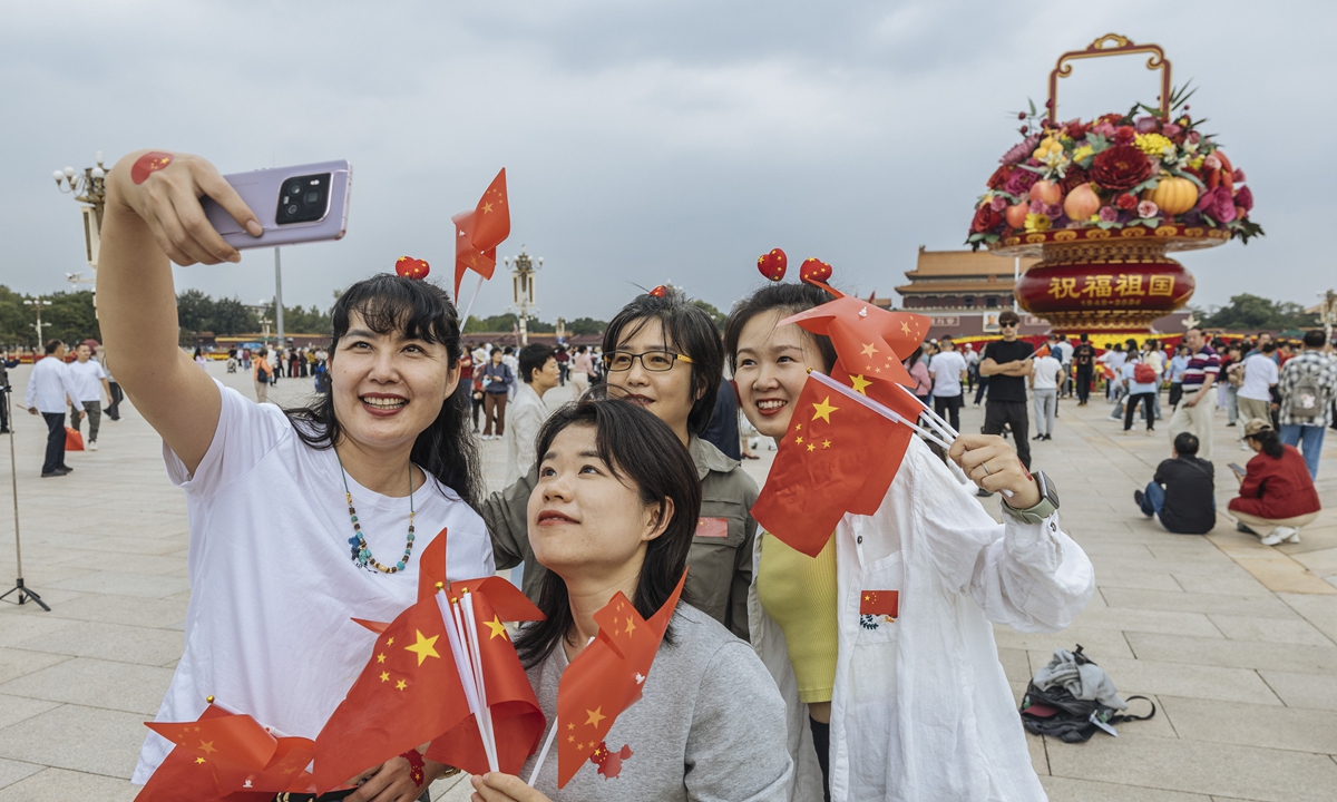 Tourists pose for a photo in front of a giant floral basket at Tian'anmen Square in Beijing to celebrate National Day on September 26, 2024. Photo: Li Hao/GT