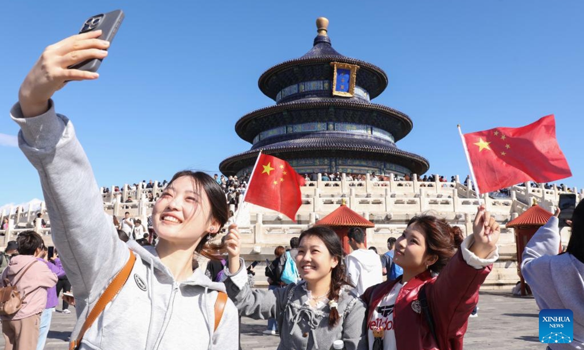 Tourists take selfies at Tiantan (Temple of Heaven) Park in Beijing, capital of China, Oct. 1, 2024. The National Day holiday period, which runs from Oct. 1 to Oct. 7 this year, is a peak travel and tourism season in China.  (Photo: Xinhua)