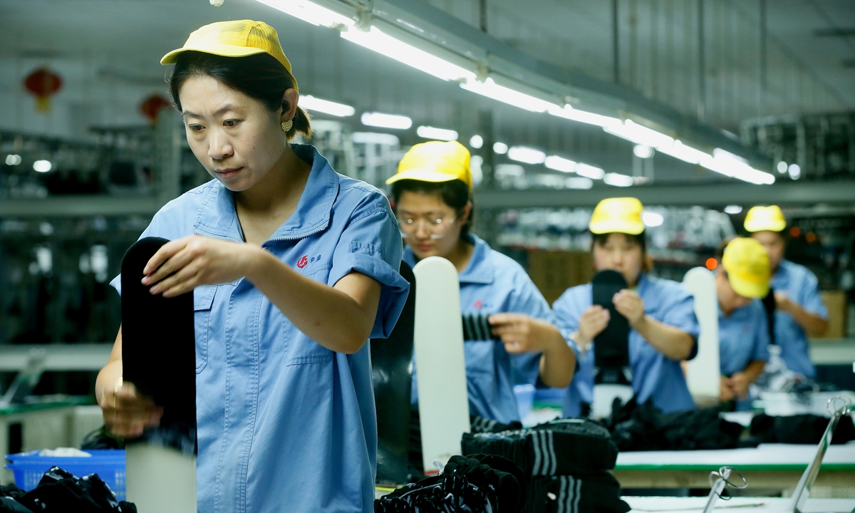 Workers are busy filling orders in a textile and clothing production workshop in Jimo district, Qingdao, East China's Shandong Province on October 7, 2024. Through policy guidance, Jimo district encourages enterprises to increase investment in new technologies, processes and products. In the first half of 2024, 85 regulated textile and clothing enterprises in Jimo achieved an output value of 8 billion yuan ($1.14 billion), a year-on-year increase of 3.8 percent. Photo: VCG