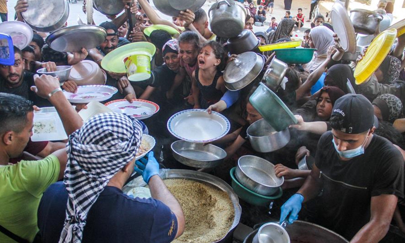 People try to get food relief in the northern Gaza Strip town of Beit Lahia, on July 18, 2024. (Photo by Mahmoud Zaki/Xinhua)