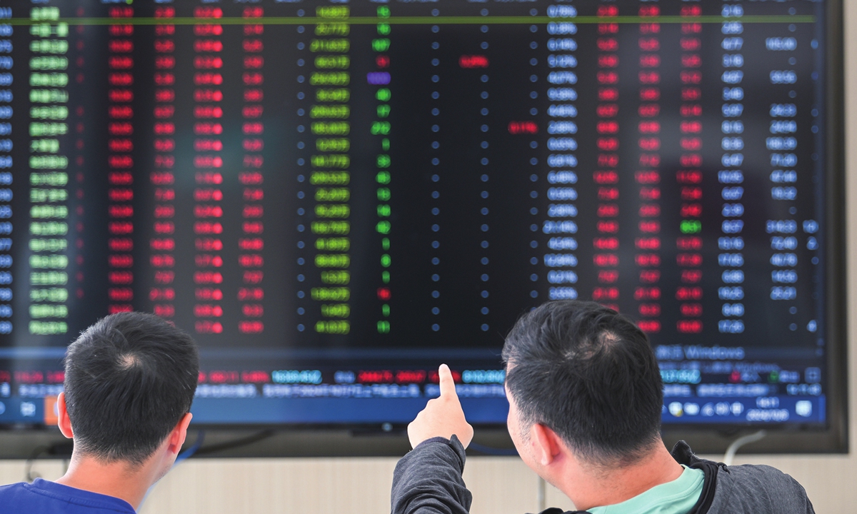 Two men view a stock market monitor in Nanjing, East China's Jiangsu Province on October 8, 2024. Photo: VCG