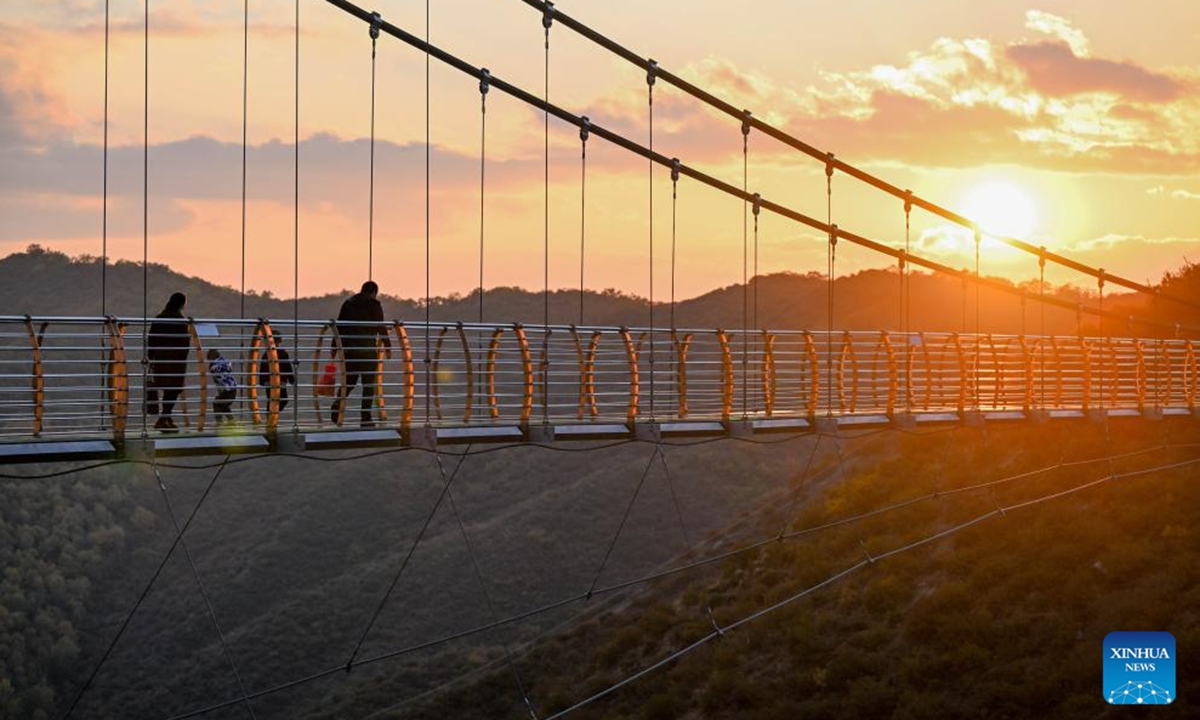 Tourists walk on a glass bridge at a scenic spot in Zhuozi County of Ulanqab, north China's Inner Mongolia Autonomous Region, Oct. 6, 2024. (Photo: Xinhua)