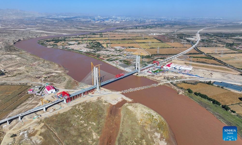 An aerial drone photo shows the construction site of the Wuhai Yellow River grand bridge in north China's Inner Mongolia Autonomous Region, Oct. 9, 2024. This grand bridge, part of the Baotou-Yinchuan high-speed railway, was joined together on Wednesday. With a designed speed of 250 km per hour, the Baotou-Yinchuan high-speed railway is a crucial link along the Beijing-Lanzhou horizontal trunk line in the nation-wide high-speed railway network. (Photo: Xinhua)