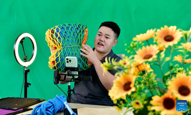 A man sells net and rope products via livestreaming in Huimin County, east China's Shandong Province, Oct. 8, 2024. Huimin County boasts a three-century history in rope and net production, and is now home to hundreds of enterprises making such products. The county holds a lion's share in the national market for ropes and nets, which are widely used in construction, sports and other sectors. (Photo: Xinhua)