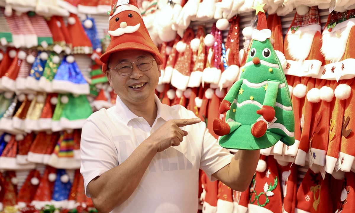 A merchant in Yiwu, East China's Zhejiang Province, showcases popular styles of Christmas hats in his booth on October 10, 2024. Festival goods are selling well in the Yiwu International Trade Market, which has more than 800 vendors offering Christmas merchandise. These vendors export Christmas items to more than 100 countries and regions each year. Photo: VCG
