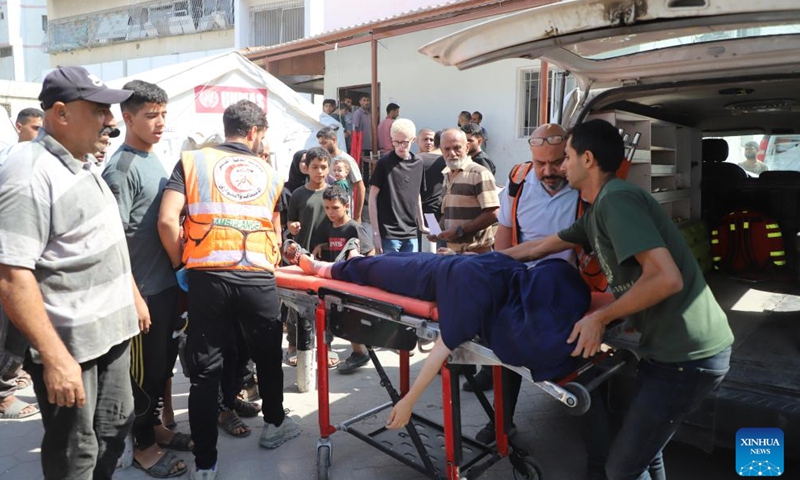 Medics evacuate an injured man from Al-Rimal clinic building after an Israeli bombardment in Gaza City, on Oct. 10, 2024. (Photo: Xinhua)