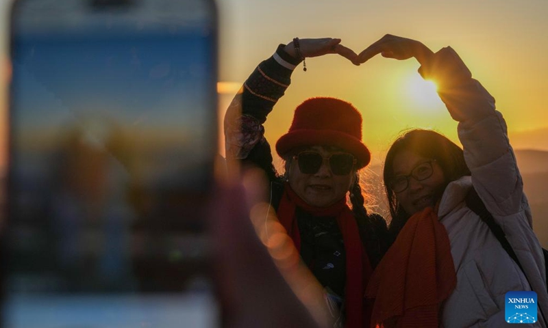 Tourists pose for photos with the rising sun in Fuyuan City, northeast China's Heilongjiang Province, Oct. 12, 2024. Fuyuan City, a famous tourist attraction, has attracted over 2.1 million visitors from January to September this year. (Photo: Xinhua)