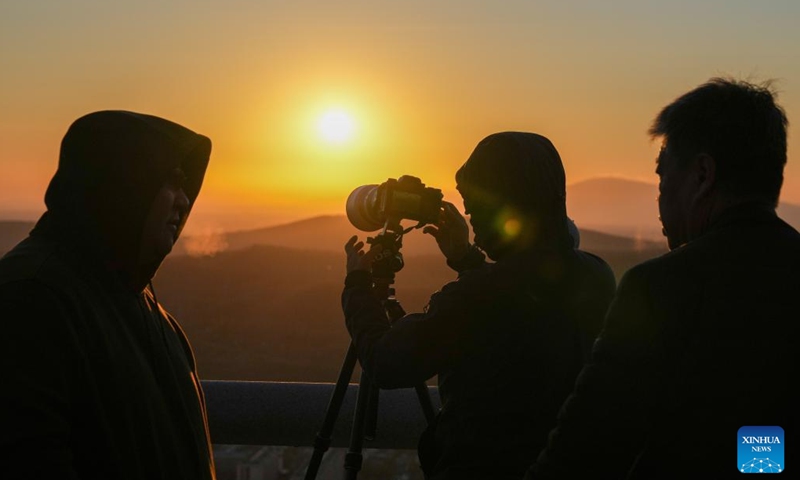 A tourist takes photos of the rising sun in Fuyuan City, northeast China's Heilongjiang Province, Oct. 12, 2024. Fuyuan City, a famous tourist attraction, has attracted over 2.1 million visitors from January to September this year. (Photo: Xinhua)