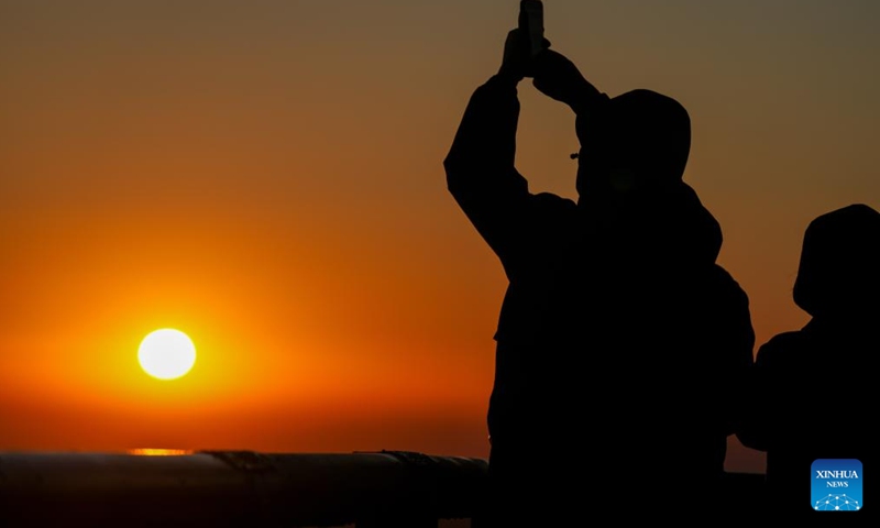 A tourist takes photos of the rising sun in Fuyuan City, northeast China's Heilongjiang Province, Oct. 12, 2024. Fuyuan City, a famous tourist attraction, has attracted over 2.1 million visitors from January to September this year. (Photo: Xinhua)