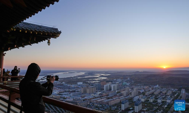 Tourists take photos of the rising sun in Fuyuan City, northeast China's Heilongjiang Province, Oct. 12, 2024. Fuyuan City, a famous tourist attraction, has attracted over 2.1 million visitors from January to September this year. (Photo: Xinhua)