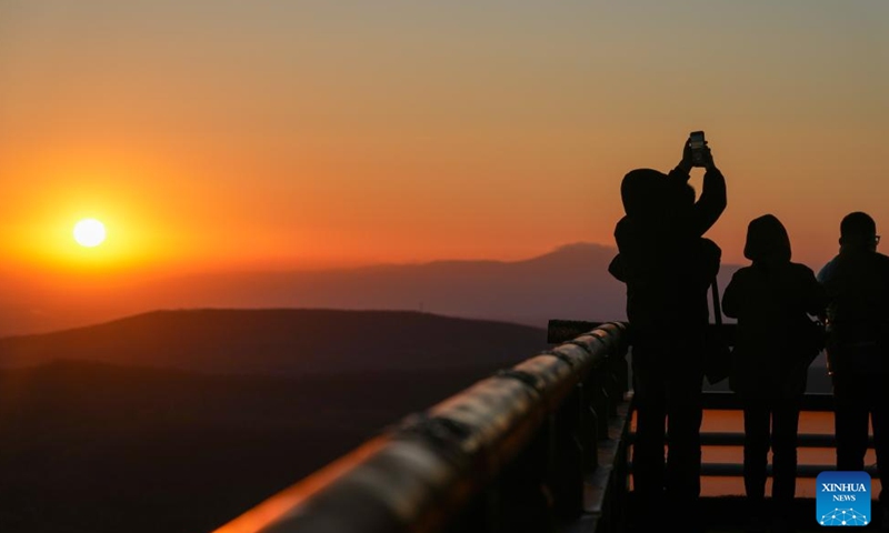 A tourist takes photos of the rising sun in Fuyuan City, northeast China's Heilongjiang Province, Oct. 12, 2024. Fuyuan City, a famous tourist attraction, has attracted over 2.1 million visitors from January to September this year. (Photo: Xinhua)