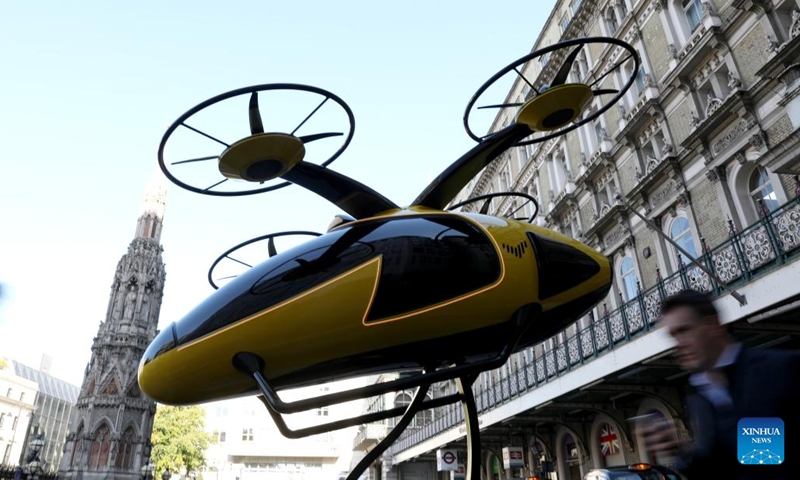 A man passes a prototype of a flying taxi on display, which is currently in development in the United Arab Emirates (UAE), in the taxi rank outside Charing Cross railway station in London, Britain, Oct. 11, 2024. (Photo: Xinhua)