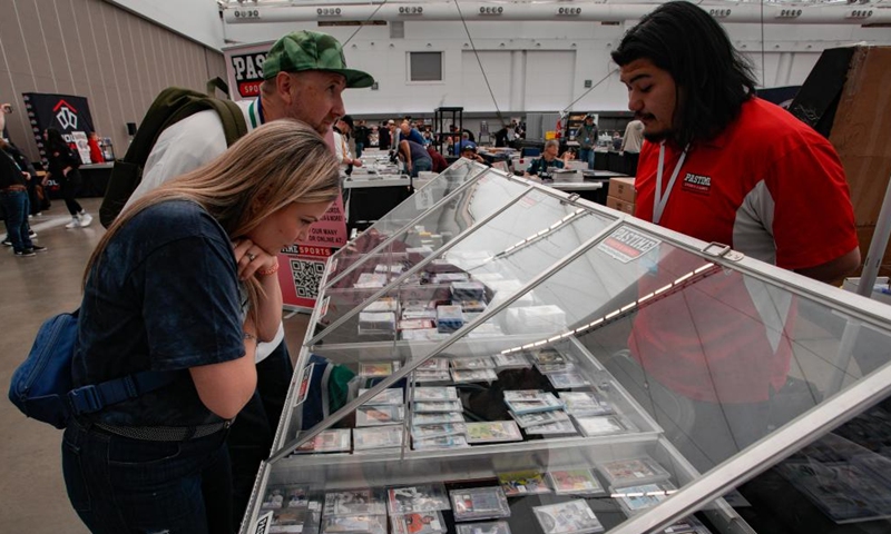 People look at the trading cards during the Vancity Card Show at the Vancouver Convention Center in Vancouver, Canada, Oct. 11, 2024. The three-day event for trading card enthusiasts, which kicked off on Friday, attracted collectors and fans of all ages. (Photo: Xinhua)