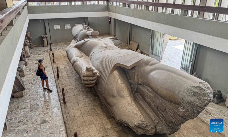 A tourist looks at the statue of ancient Egyptian King Ramses II lying on its back at the Mit Rahina Museum in Giza, Egypt, on Oct. 11, 2024. (Photo: Xinhua)