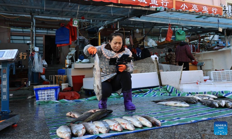 A fishmonger promotes fish via live-streaming at Dongji fish market in Fuyuan City, northeast China's Heilongjiang Province, Oct. 11, 2024. (Photo: Xinhua)