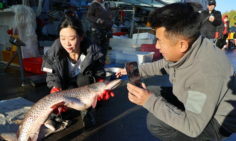 Fishmongers promote fish via live-streaming at Dongji fish market in Fuyuan City, northeast China's Heilongjiang Province, Oct. 11, 2024. (Photo: Xinhua)