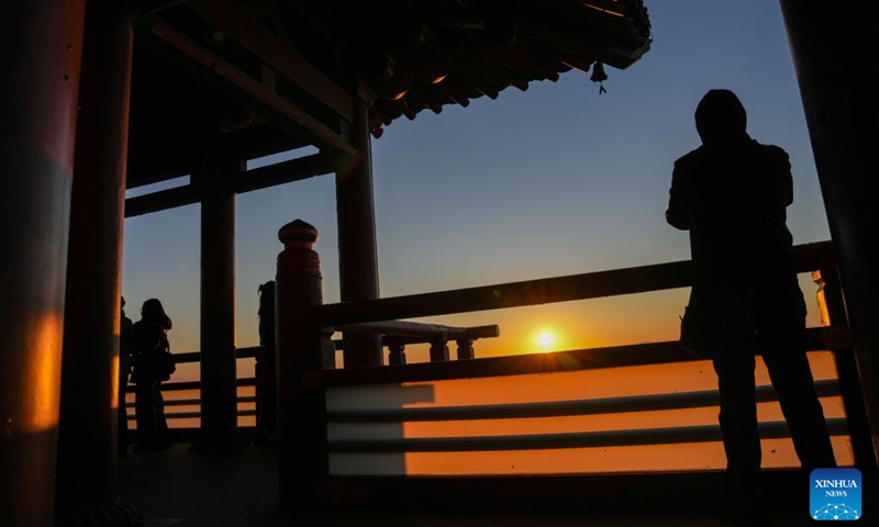 A tourist takes photos of the rising sun in Fuyuan City, northeast China's Heilongjiang Province, Oct. 12, 2024. Fuyuan City, a famous tourist attraction, has attracted over 2.1 million visitors from January to September this year. (Photo: Xinhua)