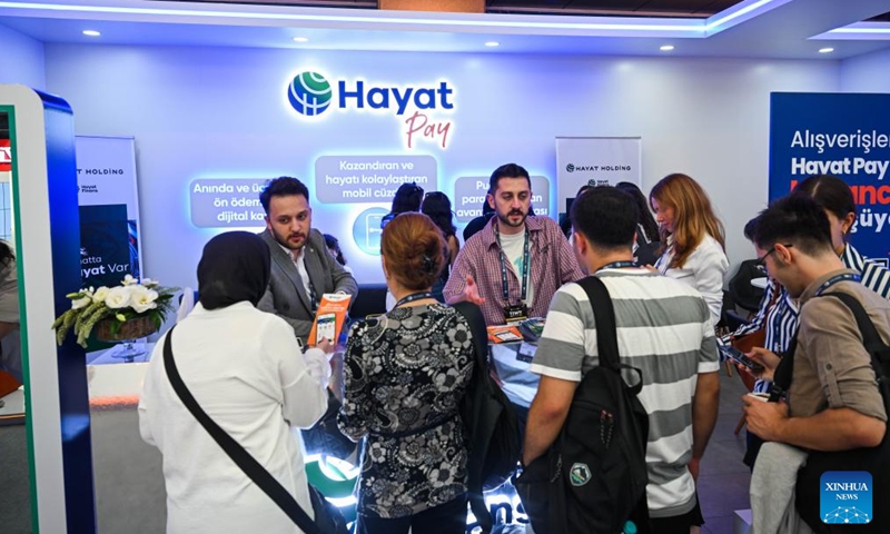 Staff members from a Turkish digital payment company talk with visitors during Türkiye Innovation Week 2024 in Istanbul, Türkiye, Oct. 11, 2024. The event was held at the Halic Congress Center in Istanbul from Oct. 10 to 12. (Photo: Xinhua)