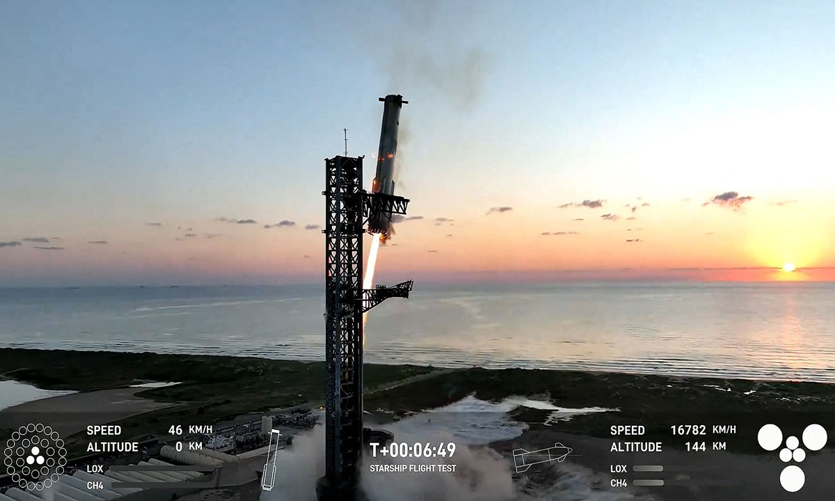 This still image taken from a SpaceX broadcast shows the Starship's Super Heavy Booster being grappled mid-air as it returns to the launch pad at Starbase near Boca Chica, Texas, on October 13, 2024, during the Starship Flight 5 test, which featured a successful first-ever attempt to catch the returning Super Heavy booster using mechanical 