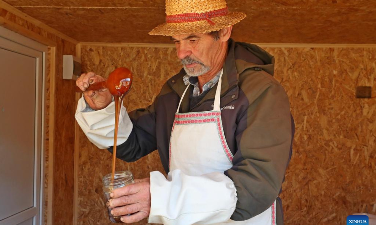 A vendor shows honey at the Belarusian Winter Agricultural Products Fair in Minsk, Belarus, Oct. 12, 2024. Belarusian Winter Agricultural Products Fair was held in Minsk on Saturday as local people buy products to prepare for the coming winter. (Photo: Xinhua)