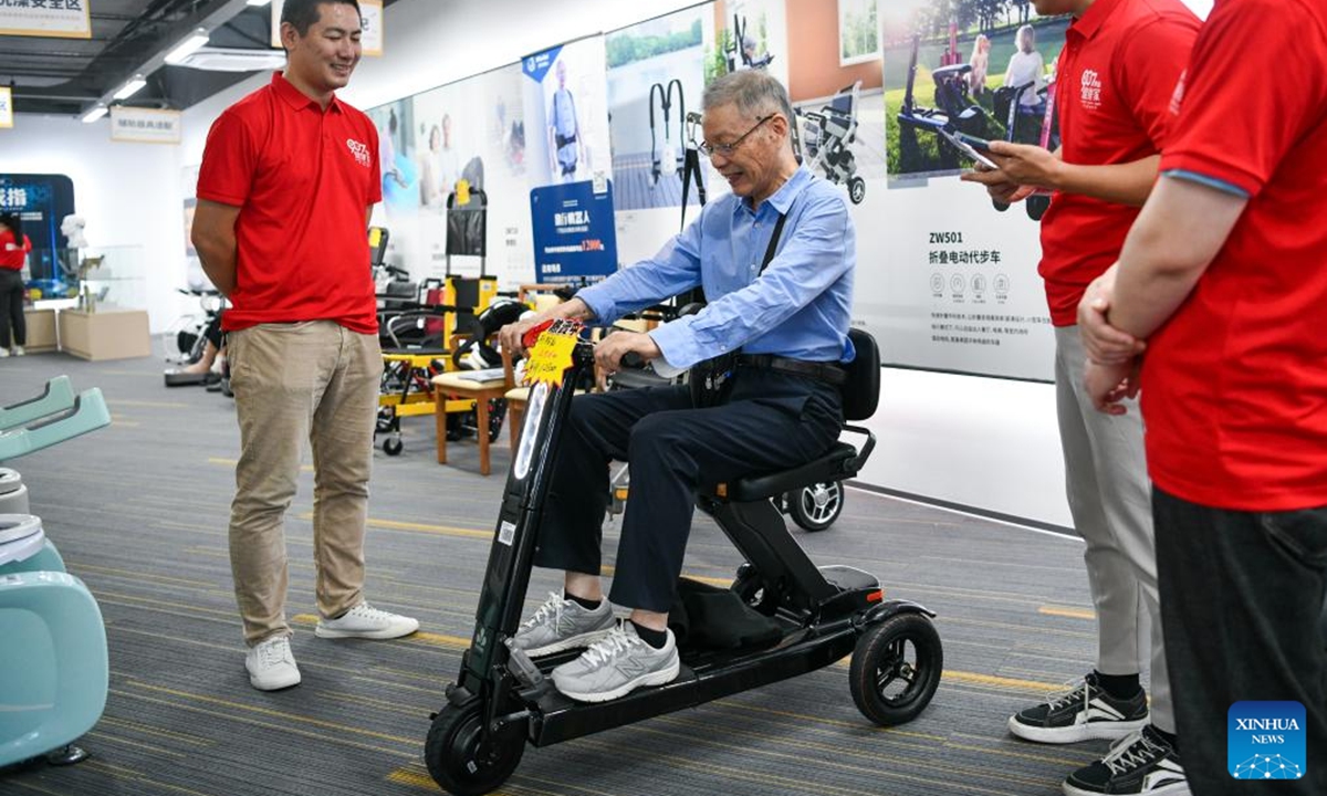 A customer tries an electric mobility scooter at an elderly product mall in Shenzhen, south China's Guangdong Province, Oct. 12, 2024. The elderly product mall in Shenzhen opened to the public recently, showcasing hundreds of smart home products under categories of home safety, entertainment, and intelligent caretaking, etc., meeting the citizens' needs for aging-friendly home renovation and living quality improvement. (Photo: Xinhua)