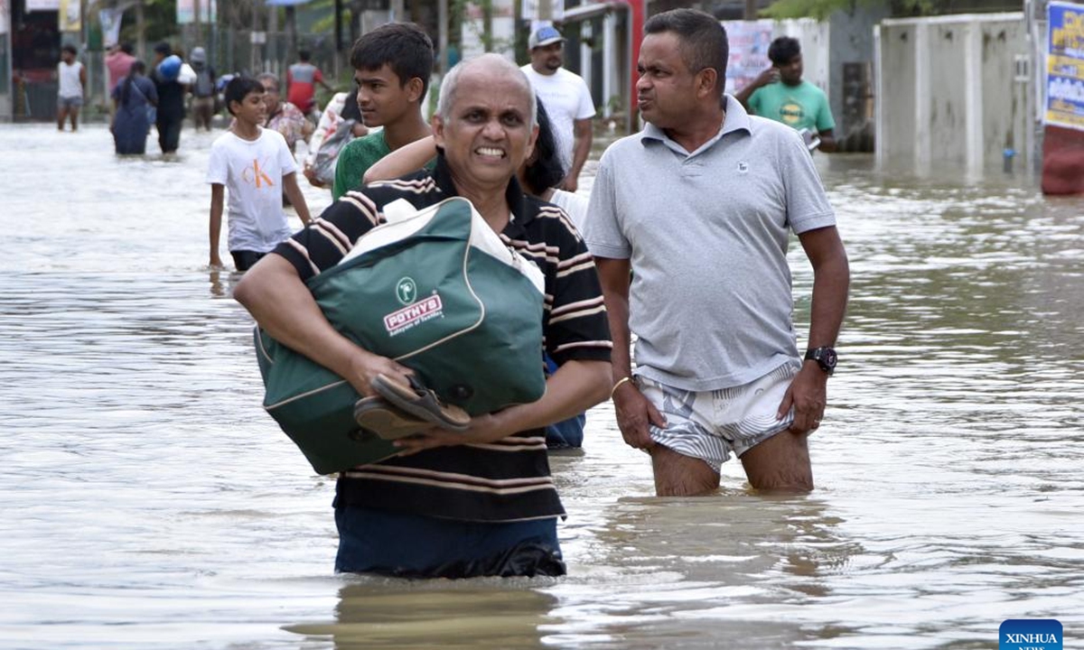 People wade through floodwater in a street in Gampaha, Sri Lanka, on Oct. 12, 2024. Sri Lankan president Anura Kumara Dissanayake has instructed officials to provide immediate relief to people affected by recent adverse weather conditions across the country, the President's Media Division (PMD) said on Saturday. (Photo: Xinhua)