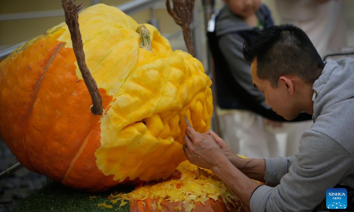 An artist carves a pumpkin during the Pumpkin Carving Show at the Metrotown shopping centre in Burnaby, British Columbia, Canada, Oct. 12, 2024.  (Photo: Xinhua)