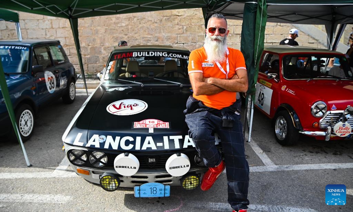 A man poses for photos with classic cars during the Mdina Grand Prix in Mdina, Malta, Oct. 12, 2024. The 14th edition of Classic Mdina Grand Prix is being held between Thursday and Sunday in Mdina. (Photo: Xinhua)