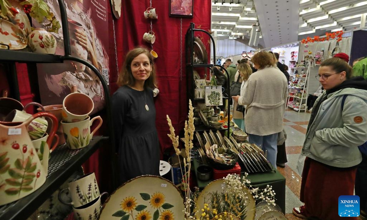 People visit the Belarusian Folk Crafts Exhibition in Minsk, Belarus, Oct. 12, 2024. The exhibition kicked off on Saturday in Minsk, where more than 200 masters of folk art presented their handmade ceramics and woodwork, jewelry and clothing, original dolls and toys, paintings, creative souvenirs and other items. The exhibition featured a variety of activities, including master classes in handicrafts, fashion shows and exhibitions of works by Belarusian designers, and attracted a large number of visitors. (Photo: Xinhua)