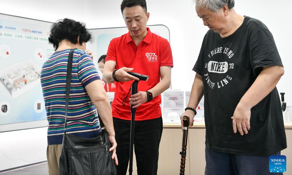 A customer tries a smart cane at an elderly product mall in Shenzhen, south China's Guangdong Province, Oct. 12, 2024. The elderly product mall in Shenzhen opened to the public recently, showcasing hundreds of smart home products under categories of home safety, entertainment, and intelligent caretaking, etc., meeting the citizens' needs for aging-friendly home renovation and living quality improvement. (Photo: Xinhua)