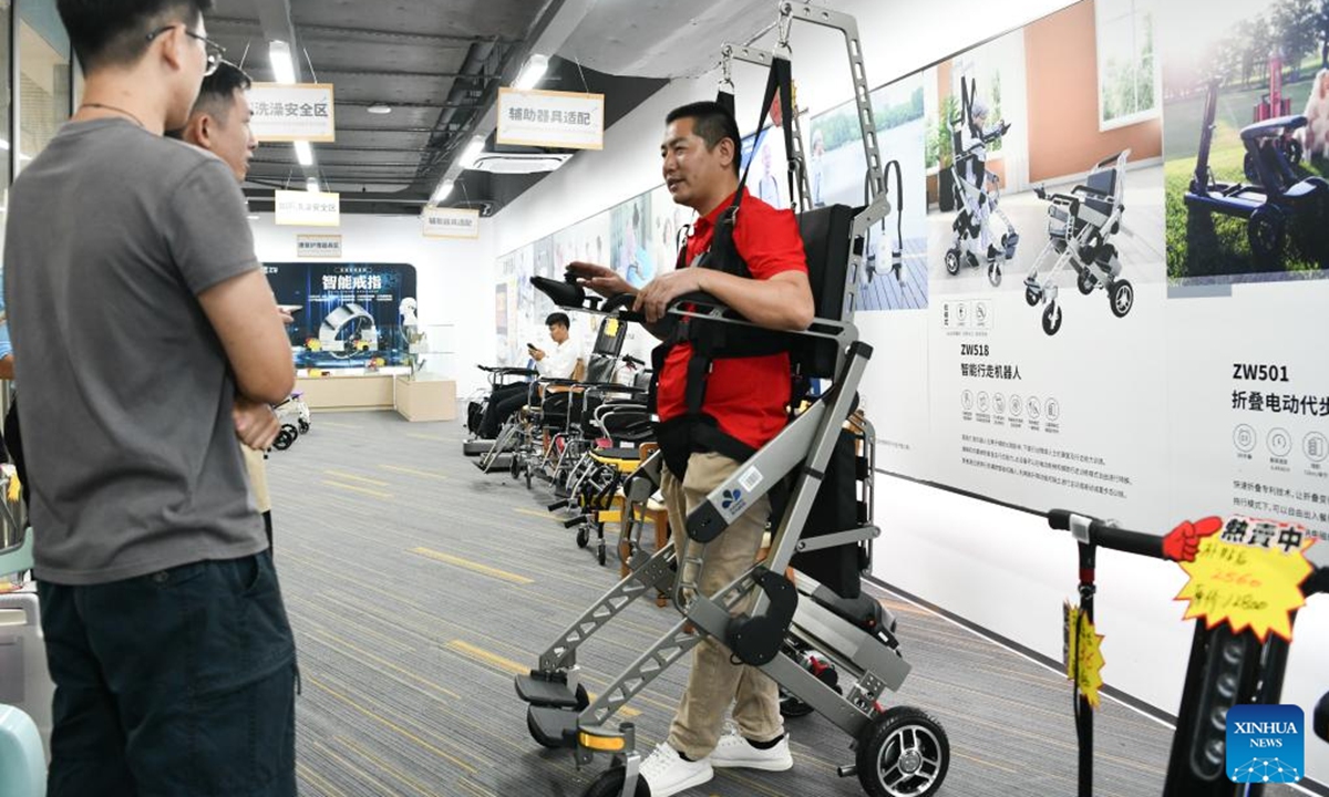 A worker demonstrates an intelligent walking robot at an elderly product mall in Shenzhen, south China's Guangdong Province, Oct. 12, 2024. The elderly product mall in Shenzhen opened to the public recently, showcasing hundreds of smart home products under categories of home safety, entertainment, and intelligent caretaking, etc., meeting the citizens' needs for aging-friendly home renovation and living quality improvement. (Photo: Xinhua)