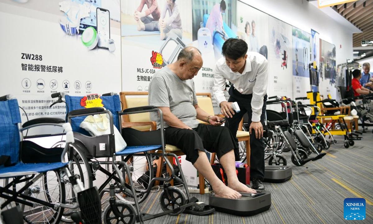 A customer tries a physiotherapy apparatus at an elderly product mall in Shenzhen, south China's Guangdong Province, Oct. 12, 2024. The elderly product mall in Shenzhen opened to the public recently, showcasing hundreds of smart home products under categories of home safety, entertainment, and intelligent caretaking, etc., meeting the citizens' needs for aging-friendly home renovation and living quality improvement. (Photo: Xinhua)