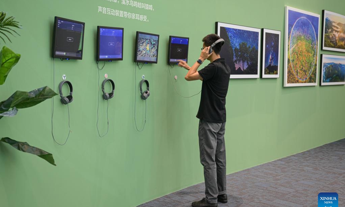 A man listens to the sound from nature at the Guarding Rainforest Homeland exhibition in Haikou, south China's Hainan Province, Oct. 13, 2024. The Guarding Rainforest Homeland exhibition has been held by the management office of the National Park of Hainan Tropical Rainforest in Haikou. Featuring animal specimens, photographs and videos, the exhibition showcases the beauty of rainforest and introduces the construction process of the National Park of Hainan Tropical Rainforest. (Photo: Xinhua)