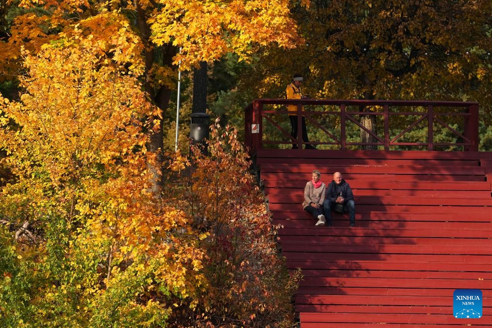 People enjoy the autumn scenery in Ogre, Latvia, Oct. 13, 2024. (Photo: Xinhua)