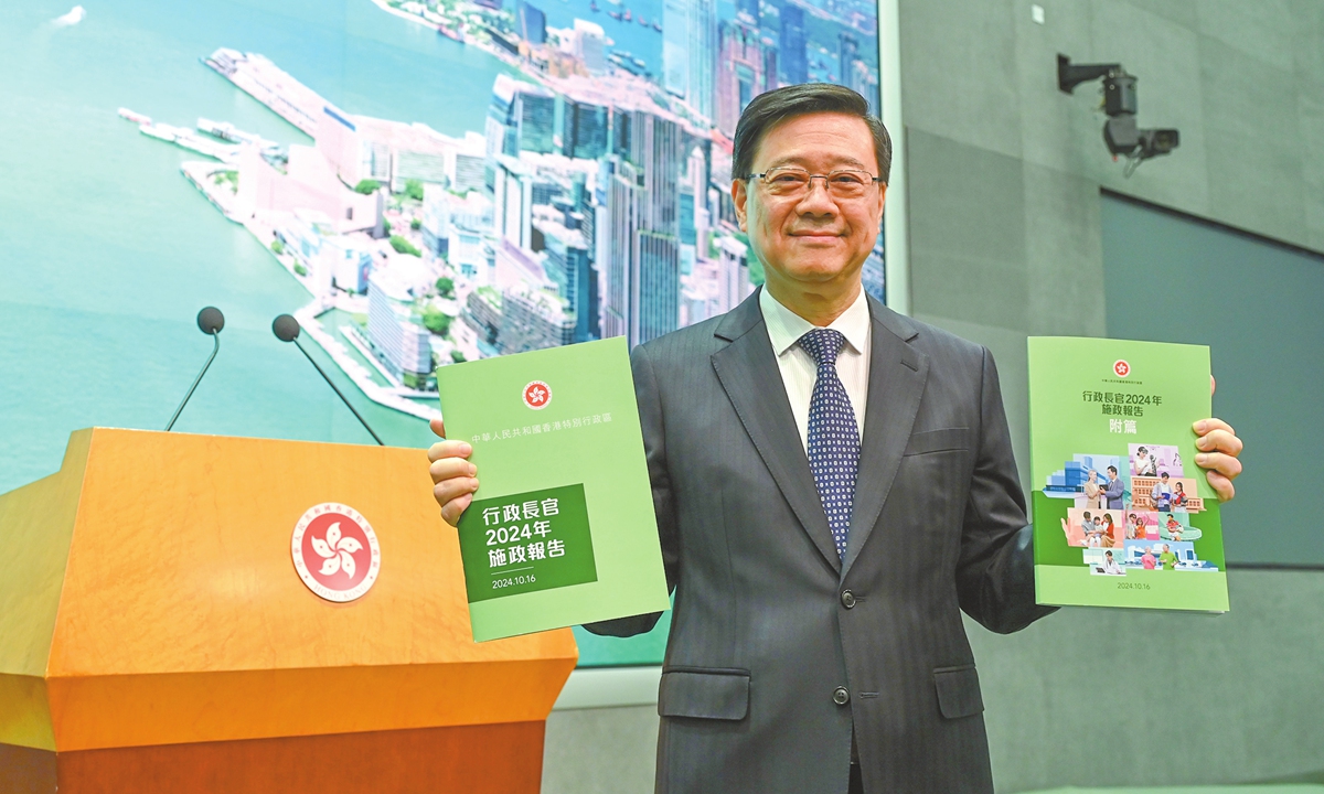 Hong Kong Chief Executive John Lee Ka-chiu holds up copies of his third policy address at a press briefing on October 15, 2024. Lee said his third policy address, to be delivered on October 16, will focus on reforms aimed at enhancing the city's development and improving people's livelihoods. Photo: VCG