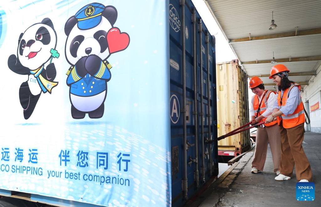 Founders of Warmpaca Ysabel Zea (R) and Ma Yuxia try opening a container of alpaca products for the seventh China International Import Expo (CIIE) at a warehouse of COSCO Shipping in Shanghai, east China, Oct. 14, 2024. The seventh CIIE is scheduled to be held from Nov. 5 to 10 in Shanghai. (Photo: Xinhua)