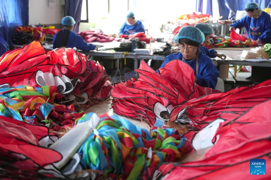 Workers make kites at a kite factory in Hanting District of Weifang, east China's Shandong Province, Oct. 14, 2024. The kite culture and thriving kite industry in Weifang have a long and rich history. In 2006, the manufacturing skill of Weifang kites was listed as a national intangible cultural heritage. (Photo: Xinhua)