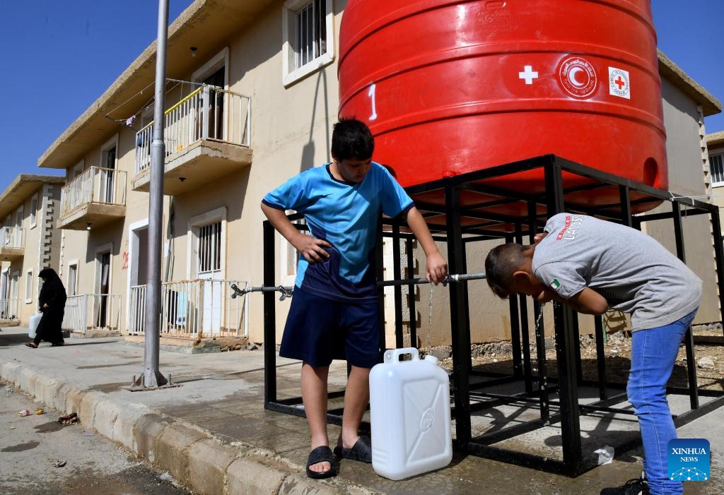 Children fleeing from Lebanon fetch water at the Harjalleh shelter center in the countryside of Damascus, Syria, on Oct. 14, 2024. The shelter center, hosting hundreds of displaced families, is managed by the Syrian government, providing essential services such as food, medical care, vaccinations for children, and access to education. (Photo: Xinhua)