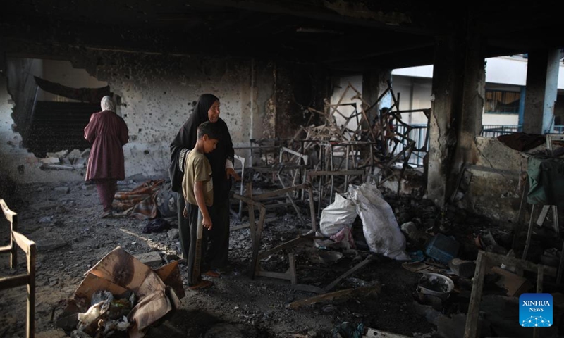 Palestinians are seen at a school housing displaced persons in Nuseirat camp in the central Gaza Strip after an Israeli attack, on Oct. 14, 2024. At least 19 Palestinians were killed and dozens of others injured on Sunday in Israeli shelling on a school housing displaced persons in the Nuseirat refugee camp of central Gaza Strip, according to Palestinian sources. (Photo: Xinhua)