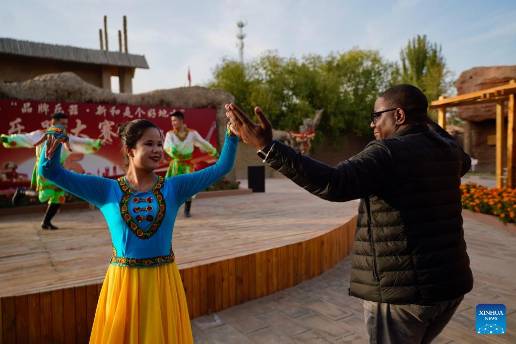 An attendee of the 6th World Media Summit interacts with a dancer in Jiayi Village of Xinhe County, northwest China's Xinjiang Uygur Autonomous Region, Oct. 15, 2024. The 6th World Media Summit opened on Monday in Urumqi, capital city of northwest China's Xinjiang Uygur Autonomous Region. (Photo: Xinhua)