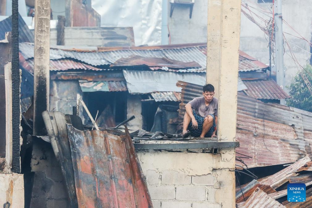 A resident returns to his charred home after a fire at a slum area in Manila, the Philippines, on Oct. 15, 2024. (Photo: Xinhua)