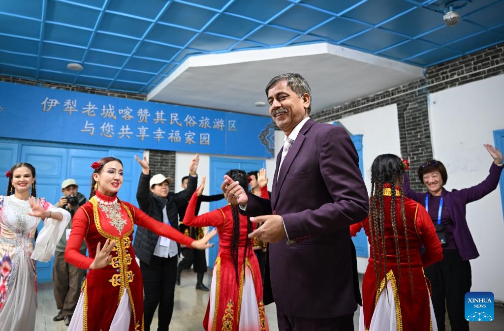 Attendees of the 6th World Media Summit interact with dancers at a folk tourism area in Yining City, northwest China's Xinjiang Uygur Autonomous Region, Oct. 15, 2024. The 6th World Media Summit opened on Monday in Urumqi, capital city of northwest China's Xinjiang Uygur Autonomous Region. (Photo: Xinhua)