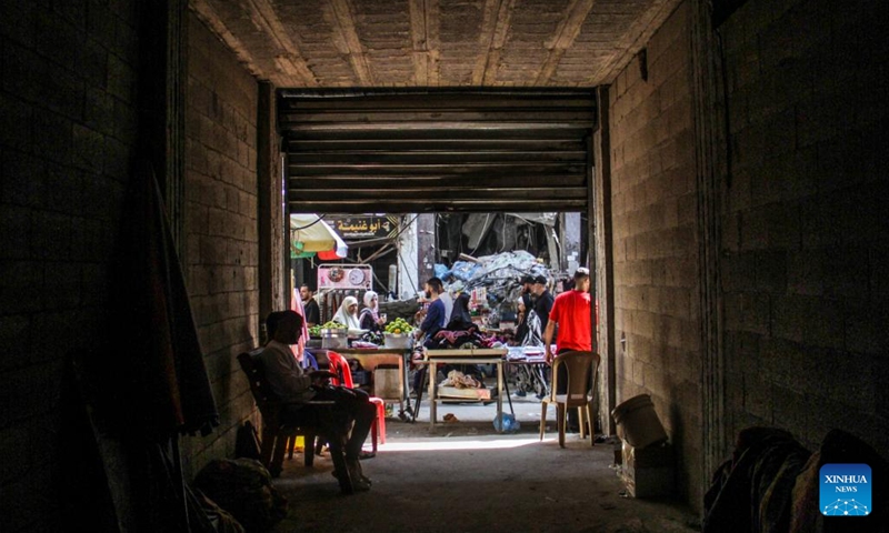 People walk through a market in Jabalia, northern Gaza Strip, on Oct. 15, 2024. (Photo: Xinhua)