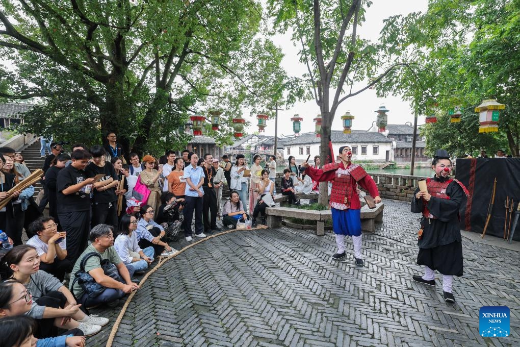 Tourists watch an open air performance during the 11th Wuzhen Theatre Festival in Wuzhen of Tongxiang City, east China's Zhejiang Province, Oct. 17, 2024. The 11th Wuzhen Theatre Festival kicked off Thursday in Wuzhen, featuring diversified performances and activities (Photo: Xinhua)